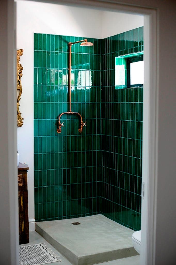 Emerald-tiled walk-in shower with copper fittings